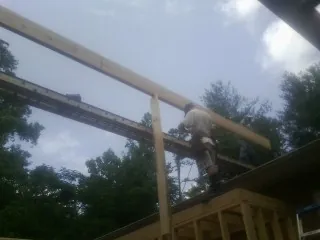Carpenter setting a ridge beam over a new addition frame — Ice Dam Removal by Roofing Brothers in Reed