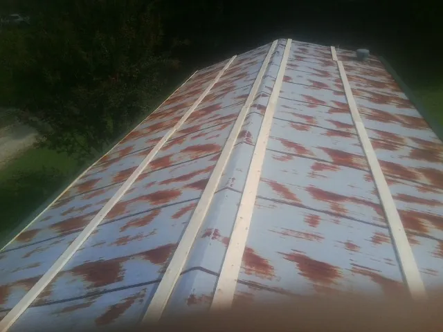 Rusted metal roof panels with new wood purlins before replacement — Storm Damage Roof Repair in Reed by Roofing Brothers