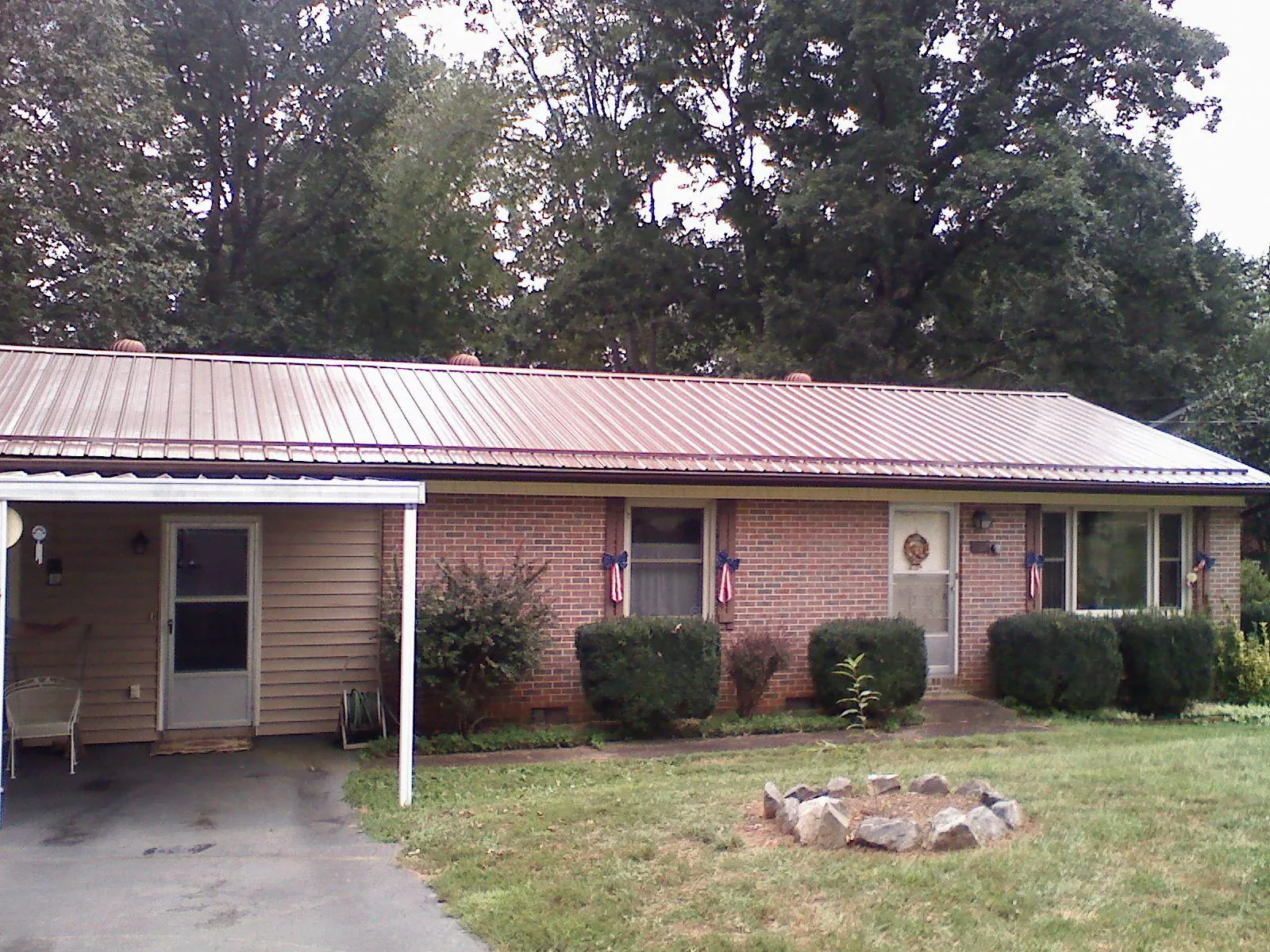 Bronze metal roof and carport on a brick ranch home — Roof Repair work by our crew in Reed